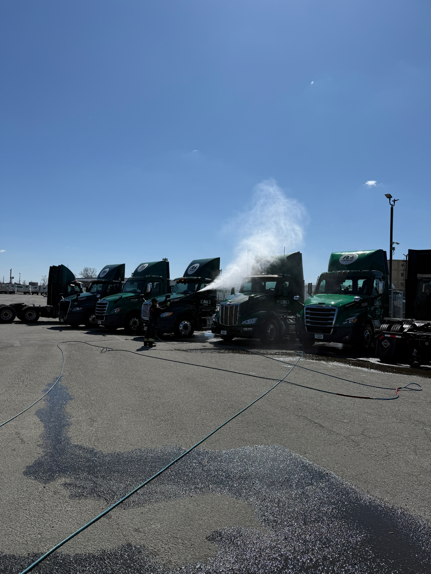 Full fleet of R+L Carriers trucks being pressure washed on-site by Sunset